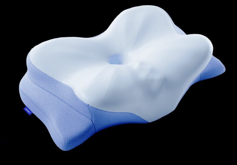 The Derila Ergo pillow on a dark background, seen from above, showing the butterfly wings on the sides and the dipped center where the head rests.